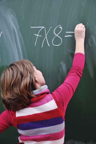 Student solving a multiplication problem on the chalkboard