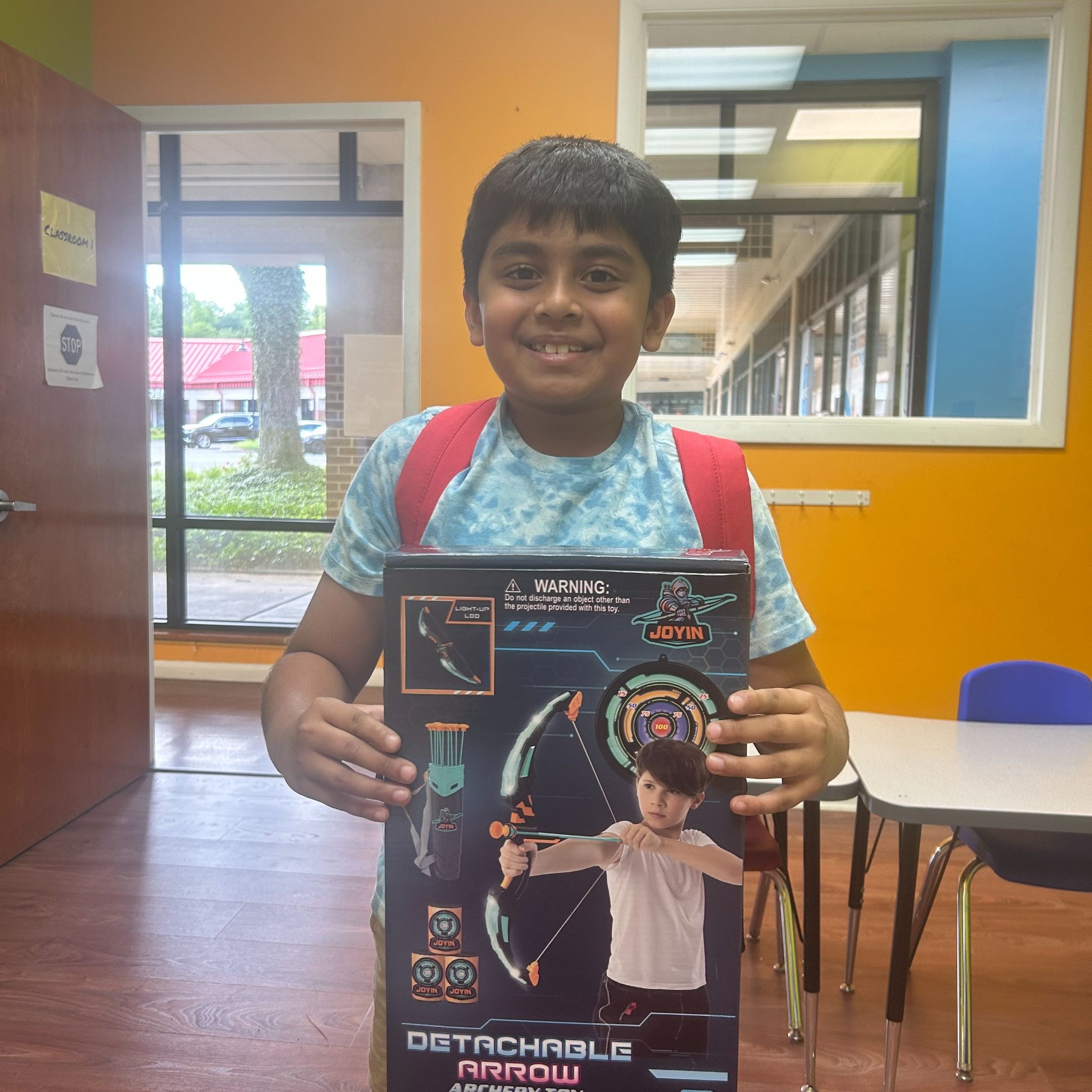 Ayaan P., Reading Log Challenge winner, holding his prize