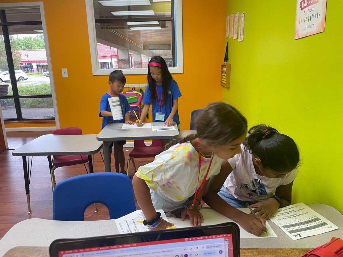 Genie Academy campers working together on word and cipher puzzles during summer camp
